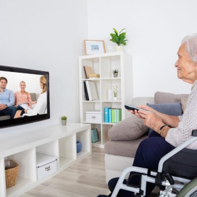 Grandmother,On,Wheelchair,Watching,Movie,On,Television,At,Home